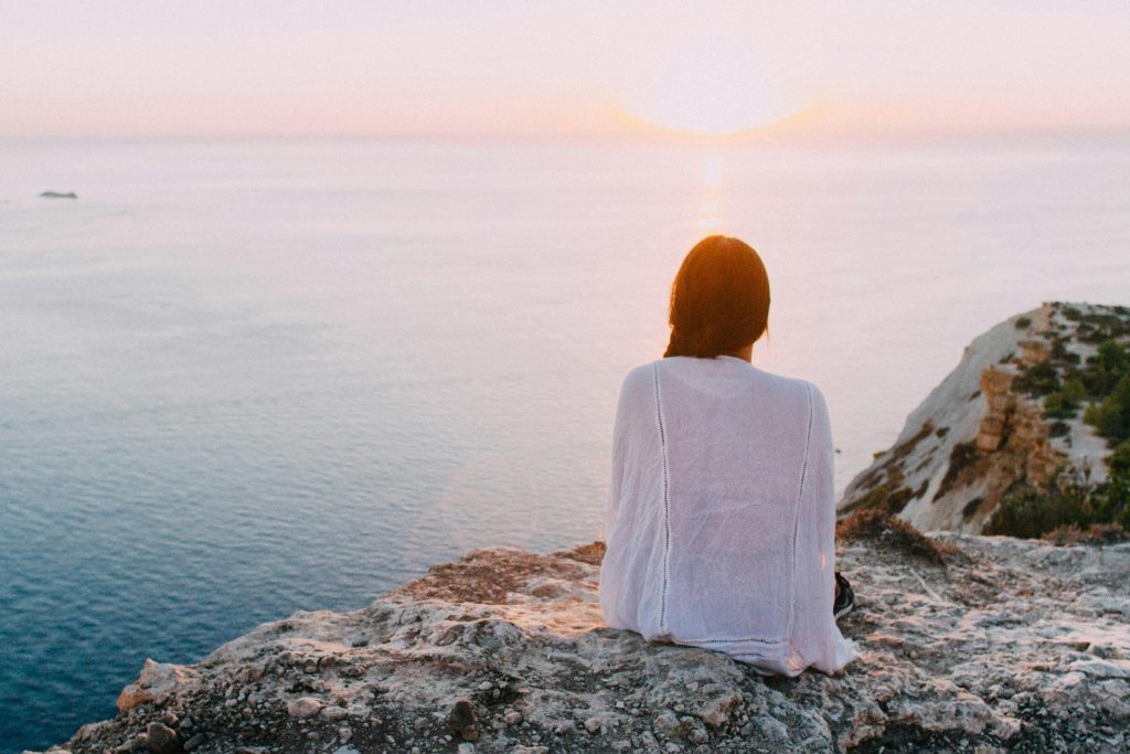 Imagen de una persona meditando en un lugar tranquilo